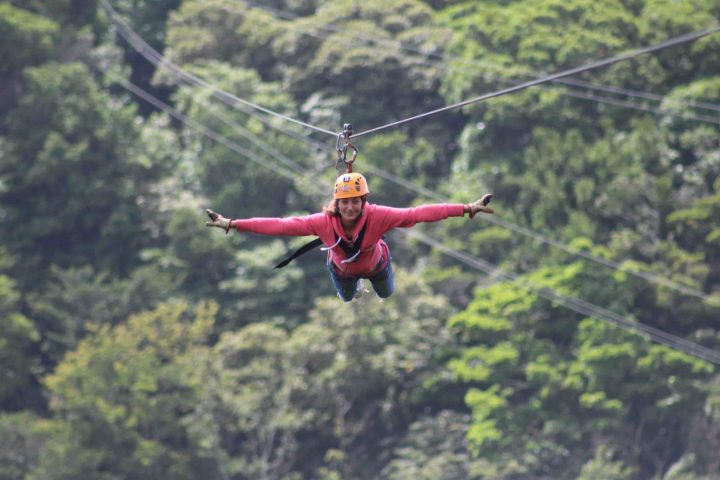 A lady doing a Superman Zip Line at the 100 Aventura Park