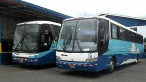 a blue bus parked on the side of a road