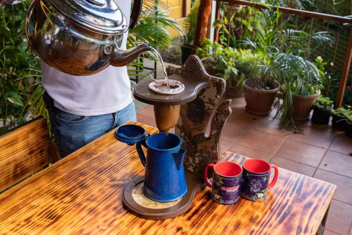 a vase full of coffee sitting on top of a wooden table