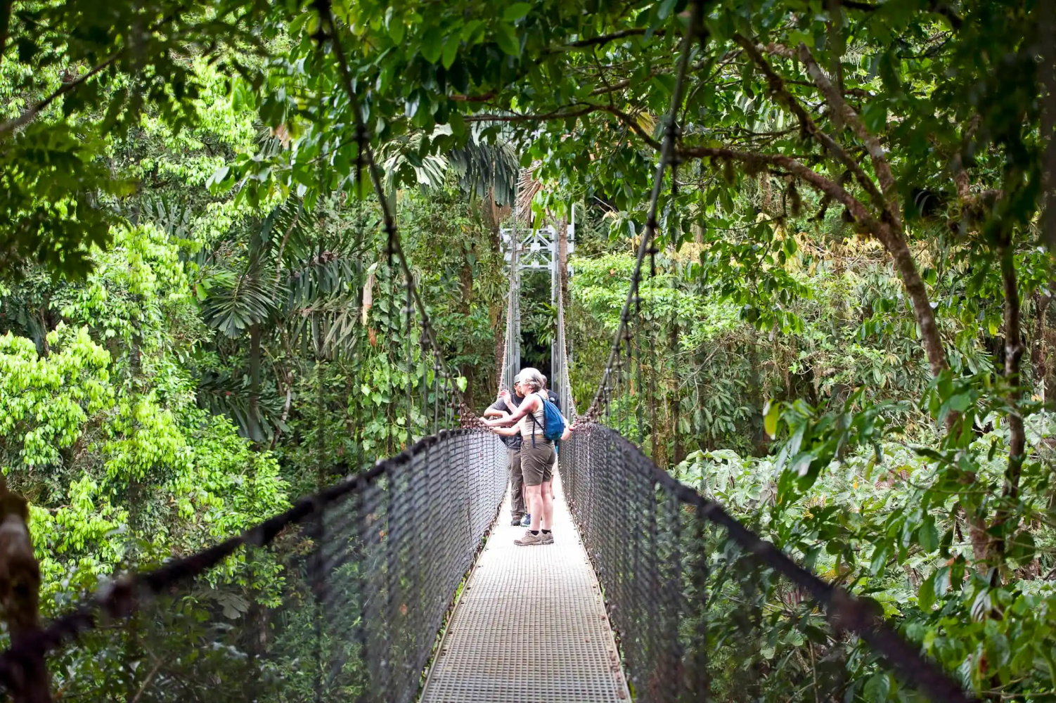 A couple walking in a hanging bridge in Arenal 